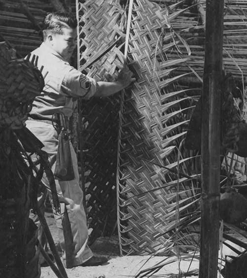WWII soldier weaving cut bamboo