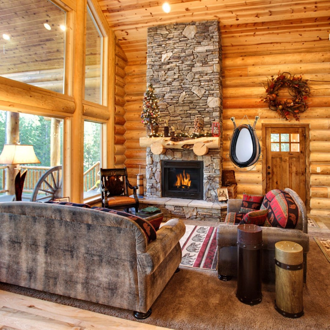 Horse collar mirror displayed on a log cabin wall beside a stone fireplace in a rustic living room decorated for the holidays.