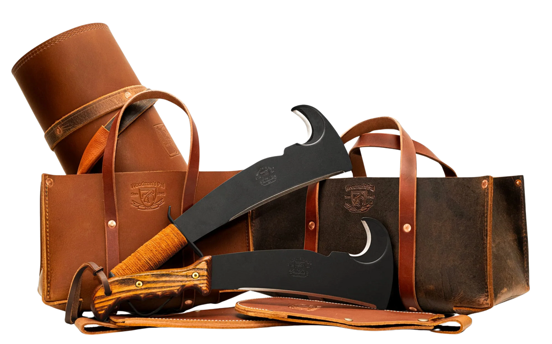 Woodman’s Pal leather log carrier and tool totes displayed with two machetes featuring wood and leather handles, and leather sheathes. 