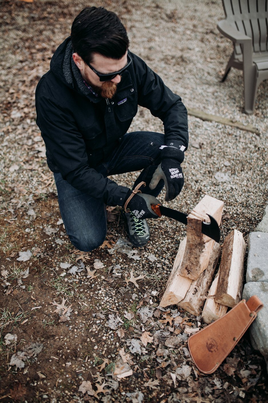 Man processing firewood with the wood-handle Woodman's Pal by a fire pit