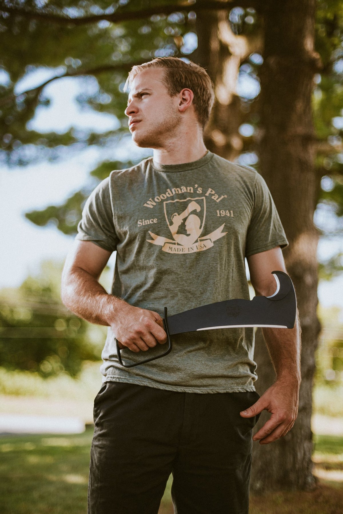 Man holding the leather-handle Woodman's Pal machete, showing its size in hand
