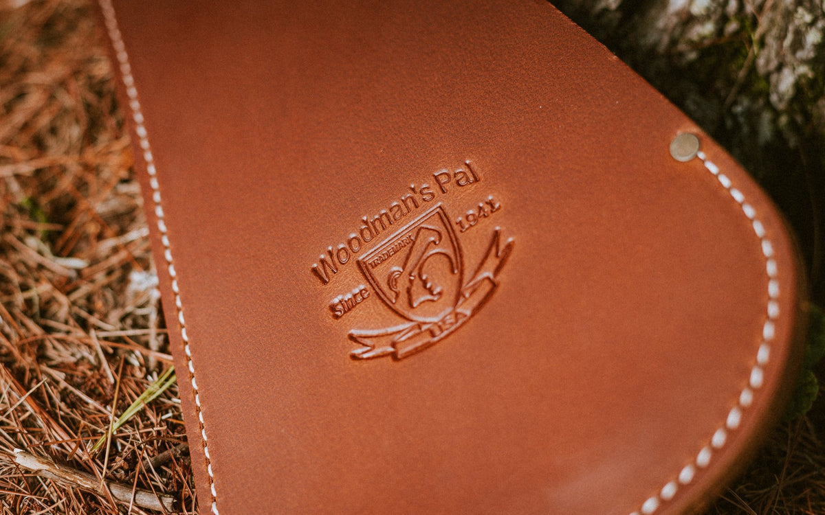 Close-up of the embossed Woodman's Pal logo on the leather sheath