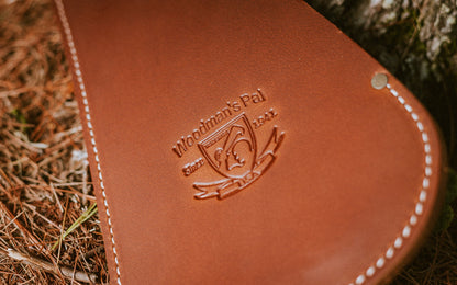 Close-up of the embossed Woodman's Pal logo on the leather sheath