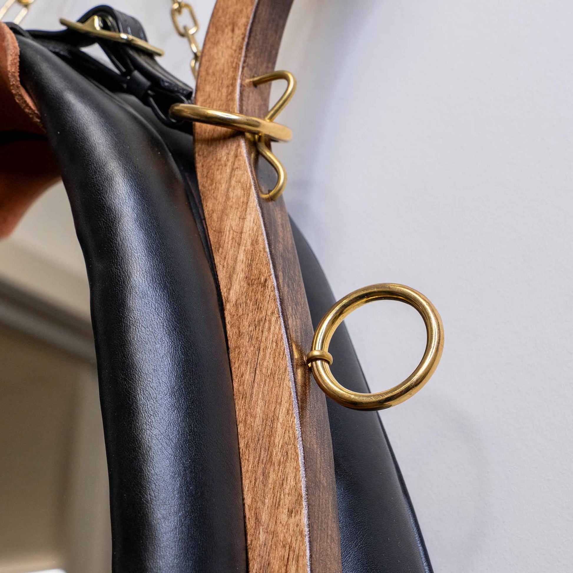 Detailed view of solid brass ring, leather, and wood construction on handmade horse collar mirror