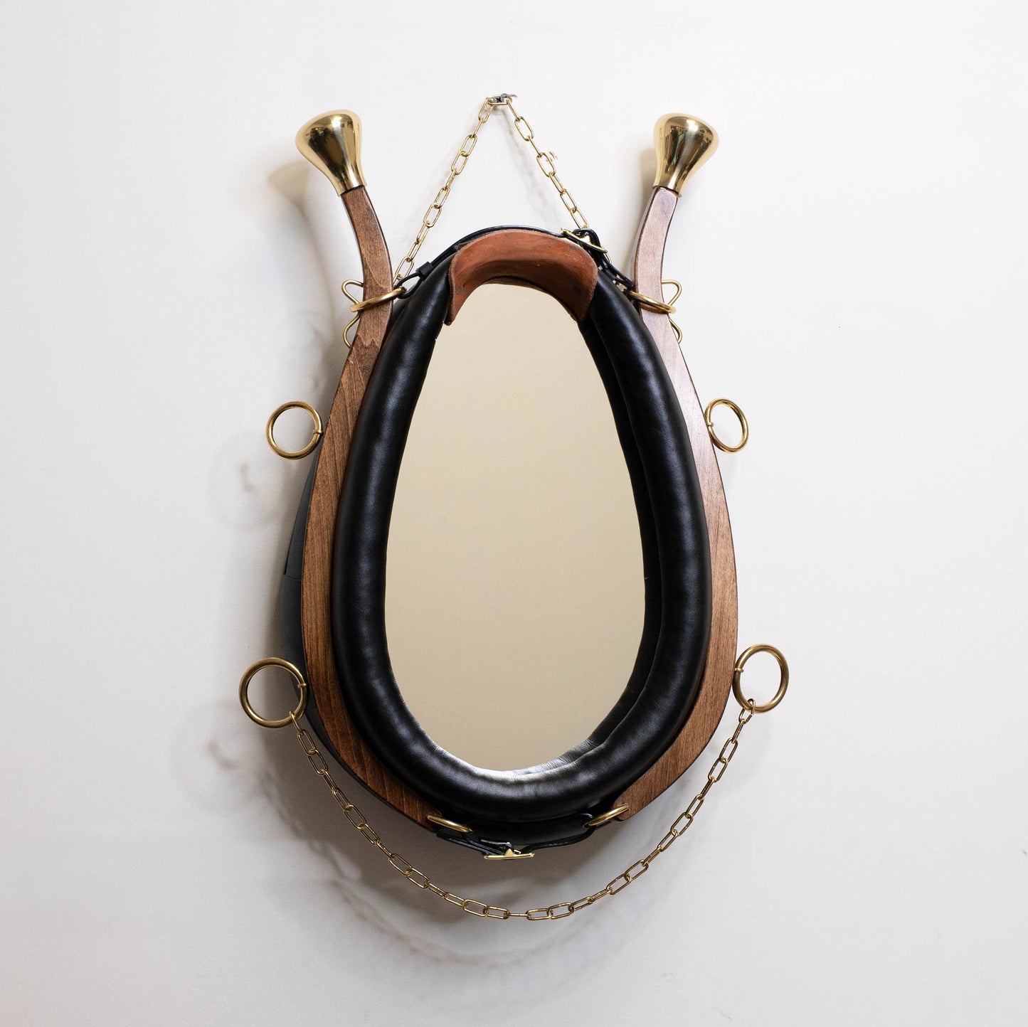 Horse collar mirror hanging on white wall showing full size and proportions