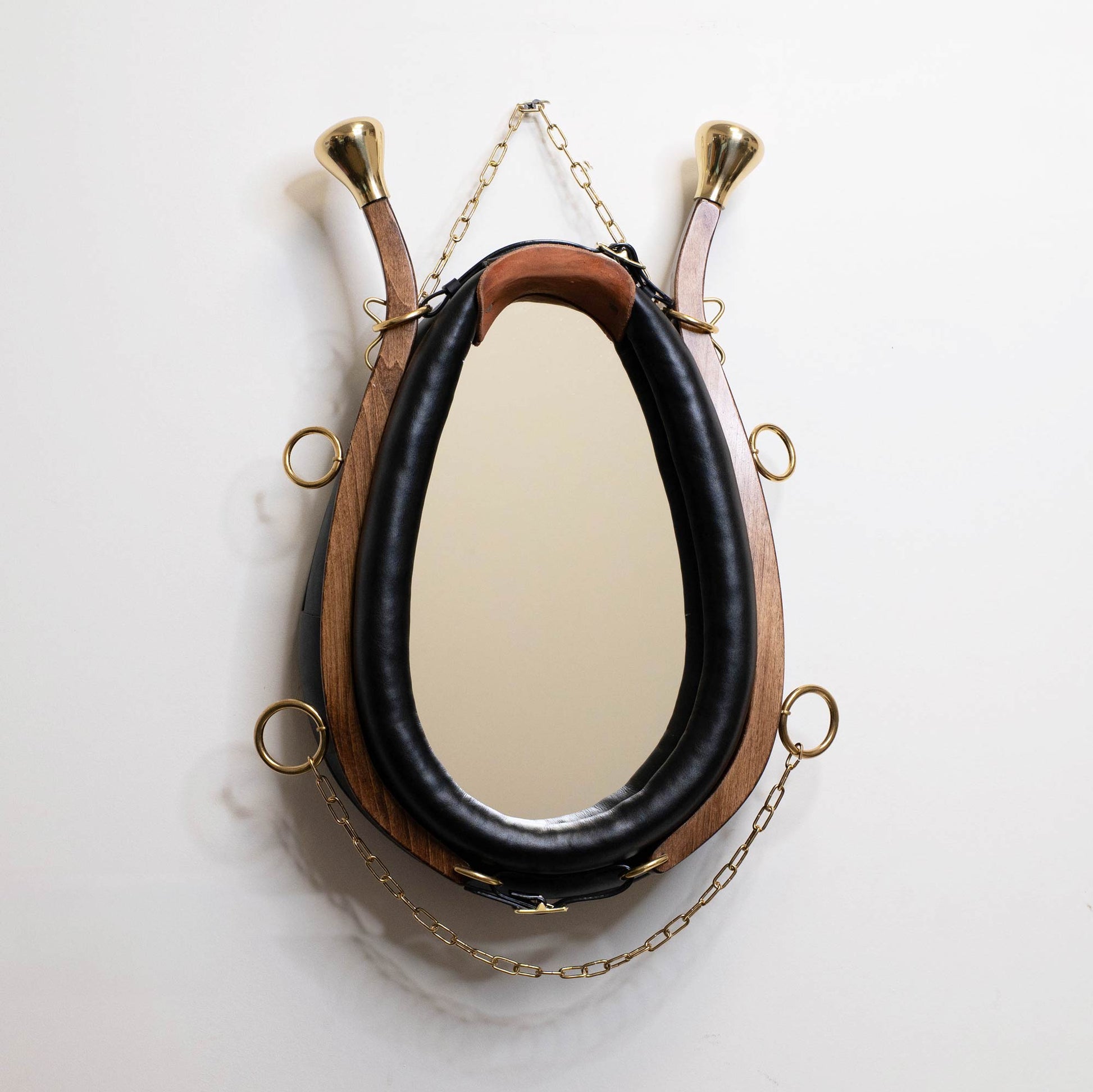 Horse collar mirror hanging on white wall showing full size and proportions