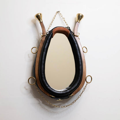 Horse collar mirror hanging on white wall showing full size and proportions